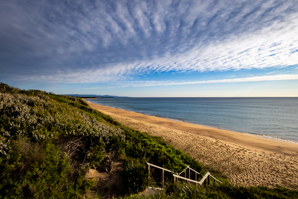 The rugged coastline and turquoise waters of Warrain Beach in Currarong, Jervis Bay region.